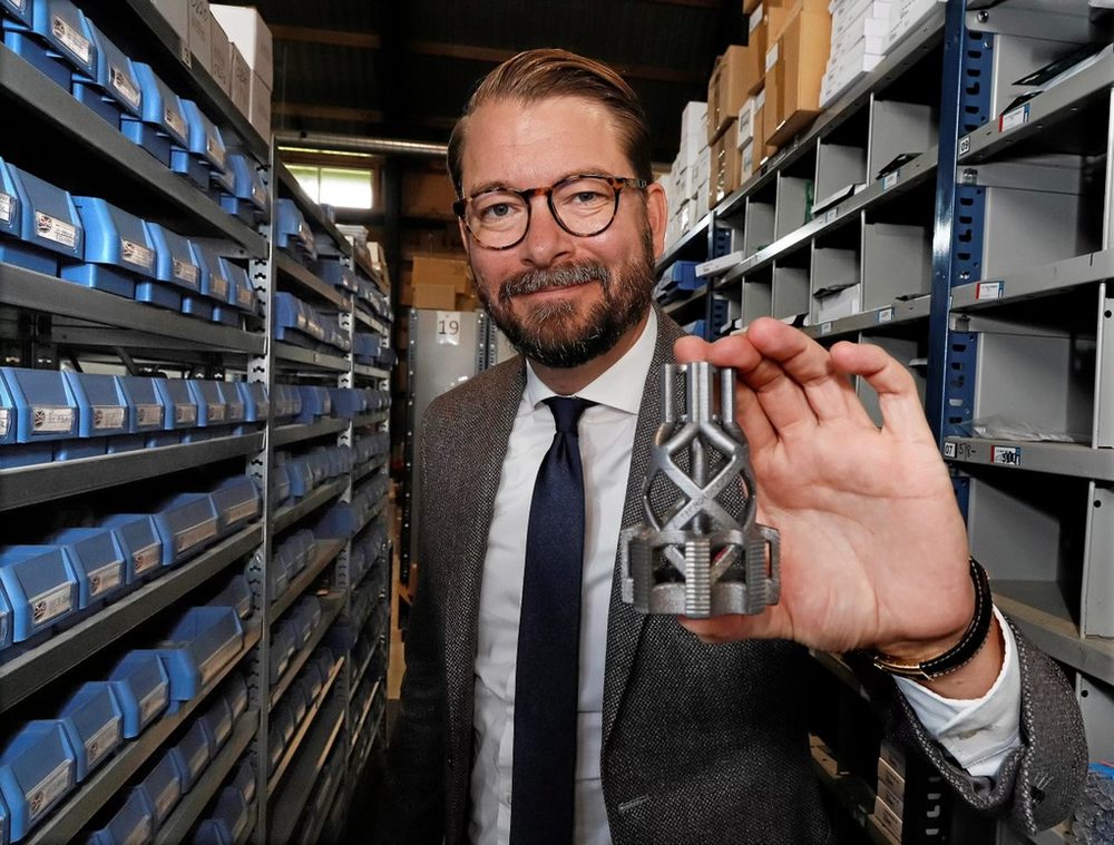 Erick Th&uuml;rmer h&aring;ller en additivt tillverkad komponent i Th&uuml;rmers lager